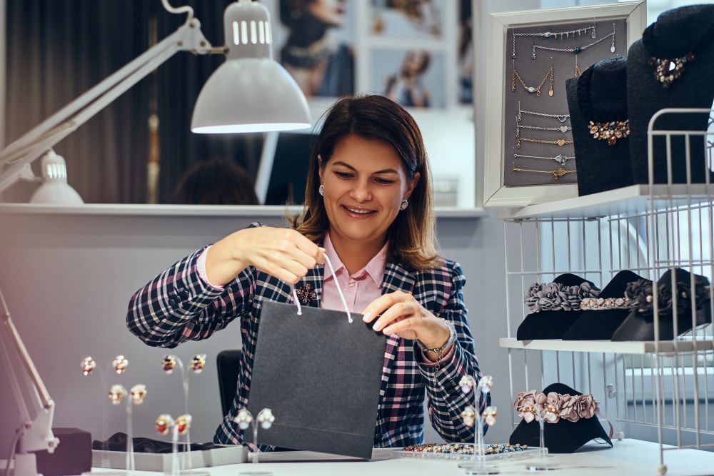 Empreendedora embalando joias de prata em loja — exemplo de quem decidiu vender prata online com profissionalismo.