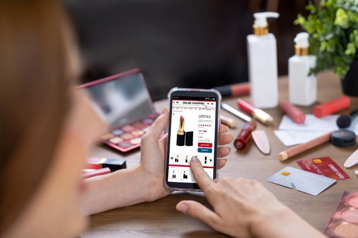 Mulher fazendo compras online na internet navegando por itens de venda. A imagem é para ilustrar o artigo sobre nomes para loja de cosméticos